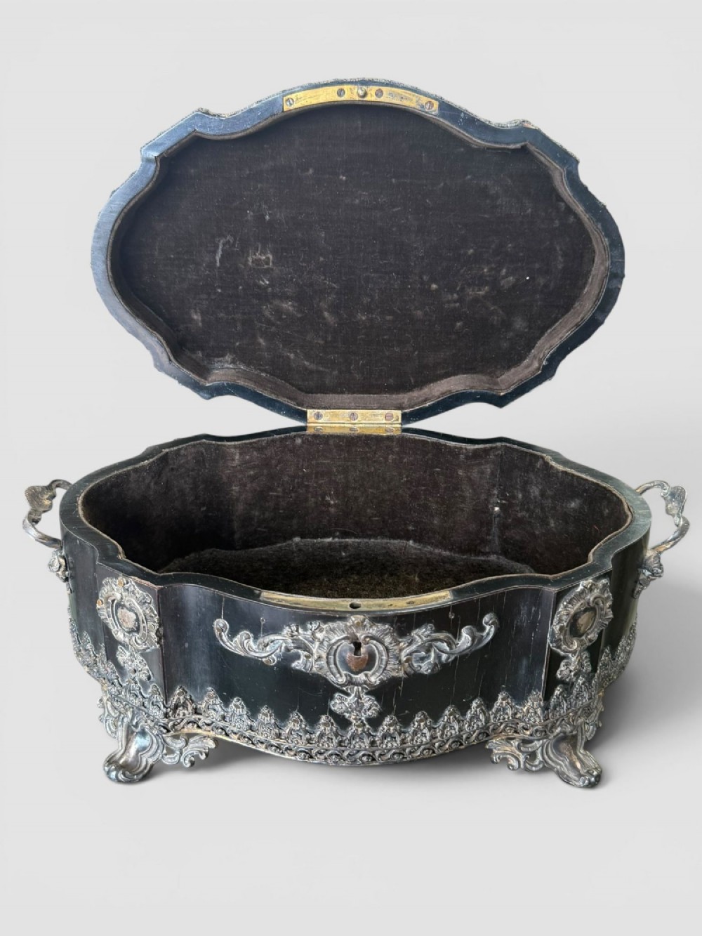 A 19th-century French ebonised serpentine table casket featuring elaborate silvered metal scrollwork mounts, raised feet, and a lid top decorated with a winged bird finial. View IX