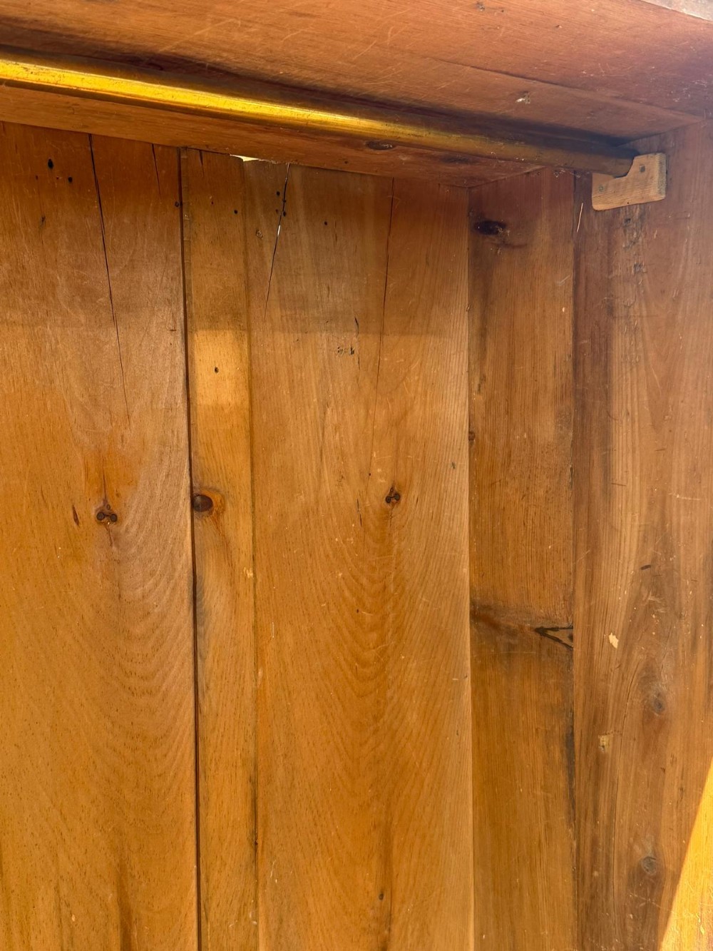 A tall Victorian pine cupboard featuring a single panelled door and bottom drawer finished in distressed black paint with a pediment top. View VII
