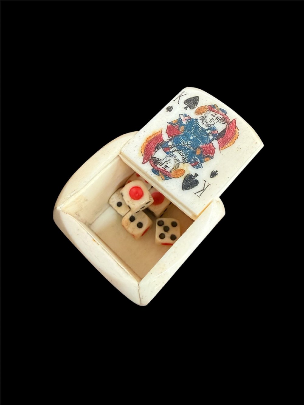 A cream-coloured carved bone poker die decorated with hand-coloured playing card suits and figures on each face. View III
