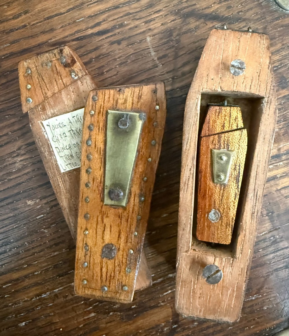 A coffin-shaped wooden puzzle snuff box decorated with a central brass plate and metal studs. View III