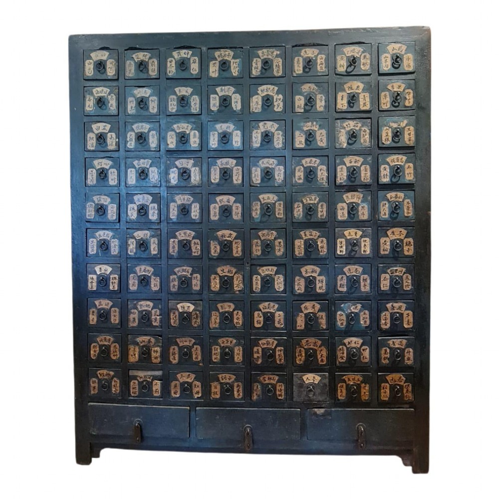 A tall dark elm Chinese apothecary chest featuring multiple small drawers inscribed with calligraphic characters above three larger base drawers.