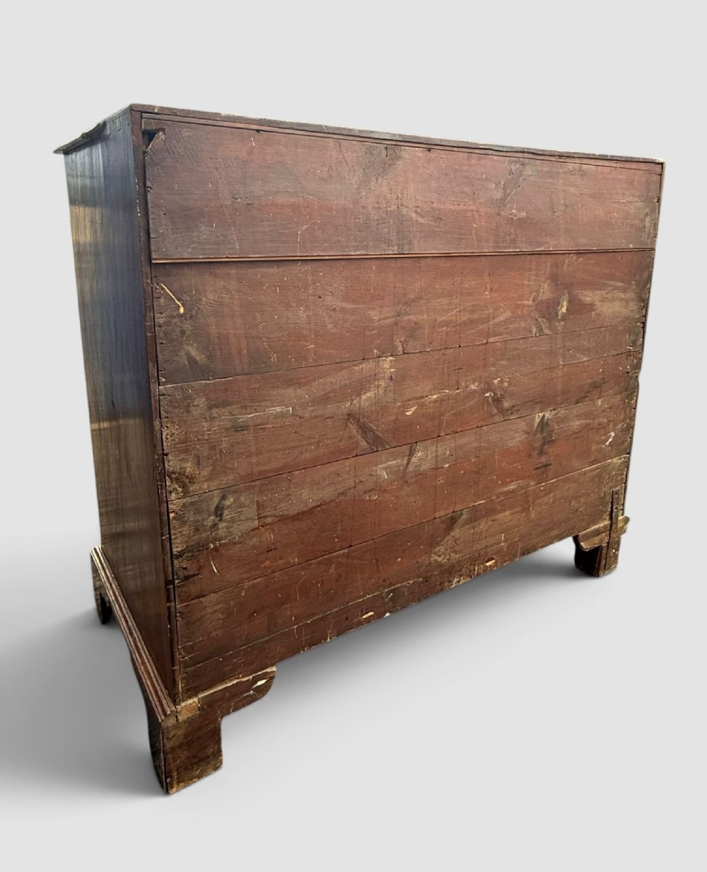 A Georgian mahogany chest of drawers featuring a two-over-three drawer configuration with brass swan-neck handles and bracket feet. View V