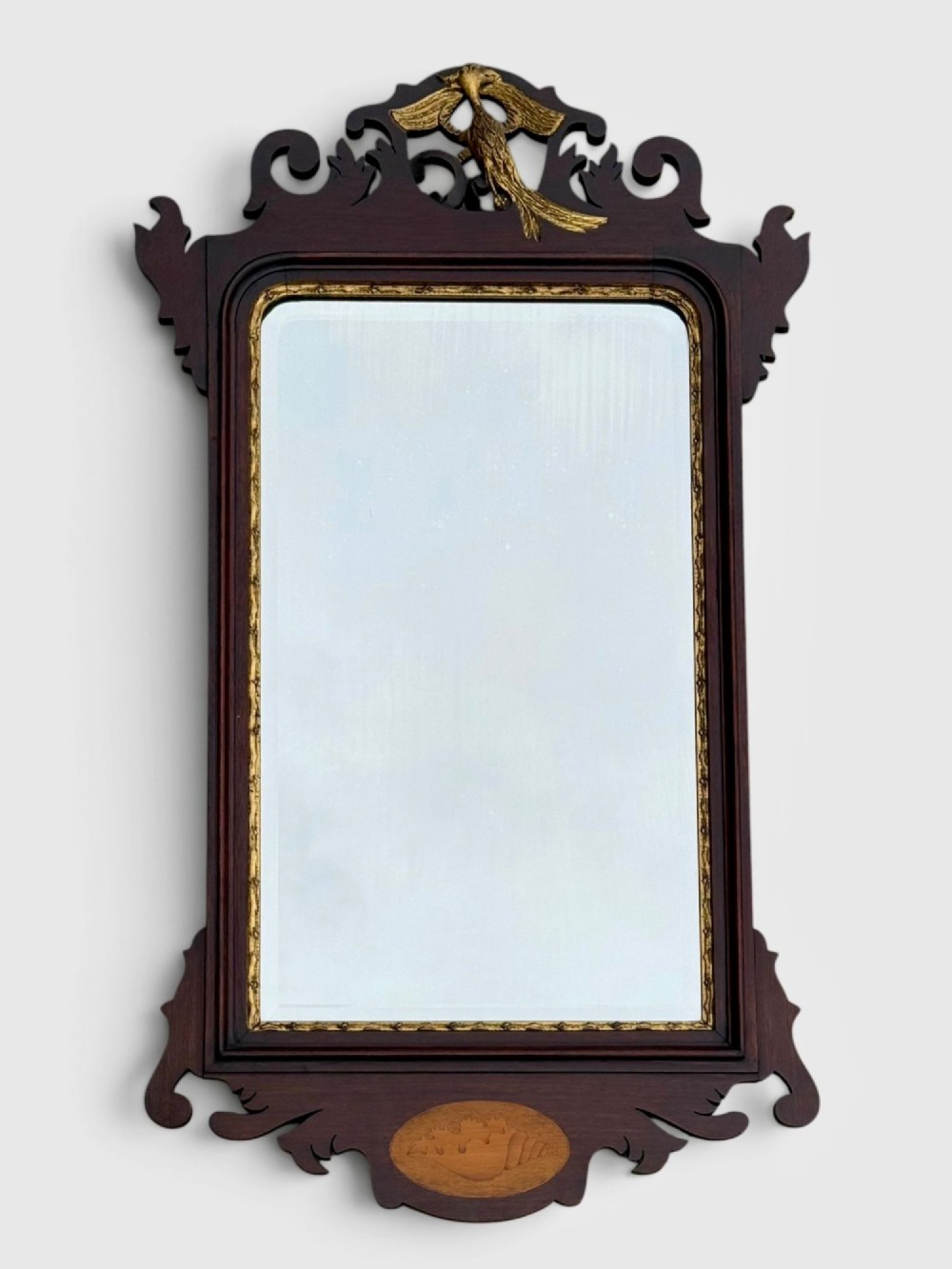 A rectangular Georgian style dark mahogany wall mirror featuring a gilded ho-ho bird crest, gilt inner slip border, and a carved shell marquetry medallion at the base.