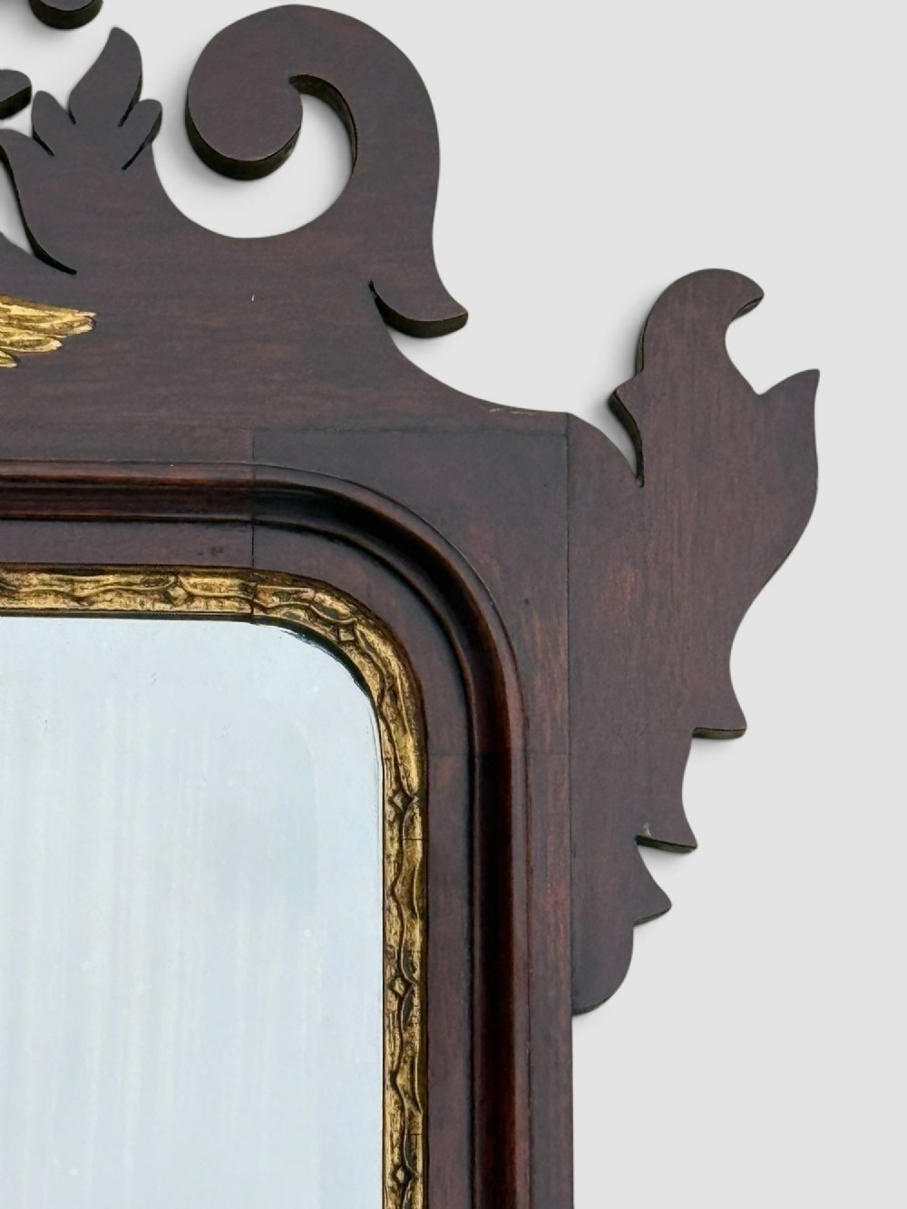 A rectangular Georgian style dark mahogany wall mirror featuring a gilded ho-ho bird crest, gilt inner slip border, and a carved shell marquetry medallion at the base. View VII