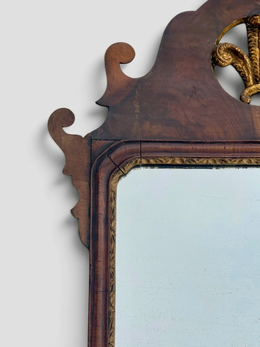 An 18th-century Georgian wall mirror featuring a carved walnut fretwork frame with a central gilded plume motif at the top. View III