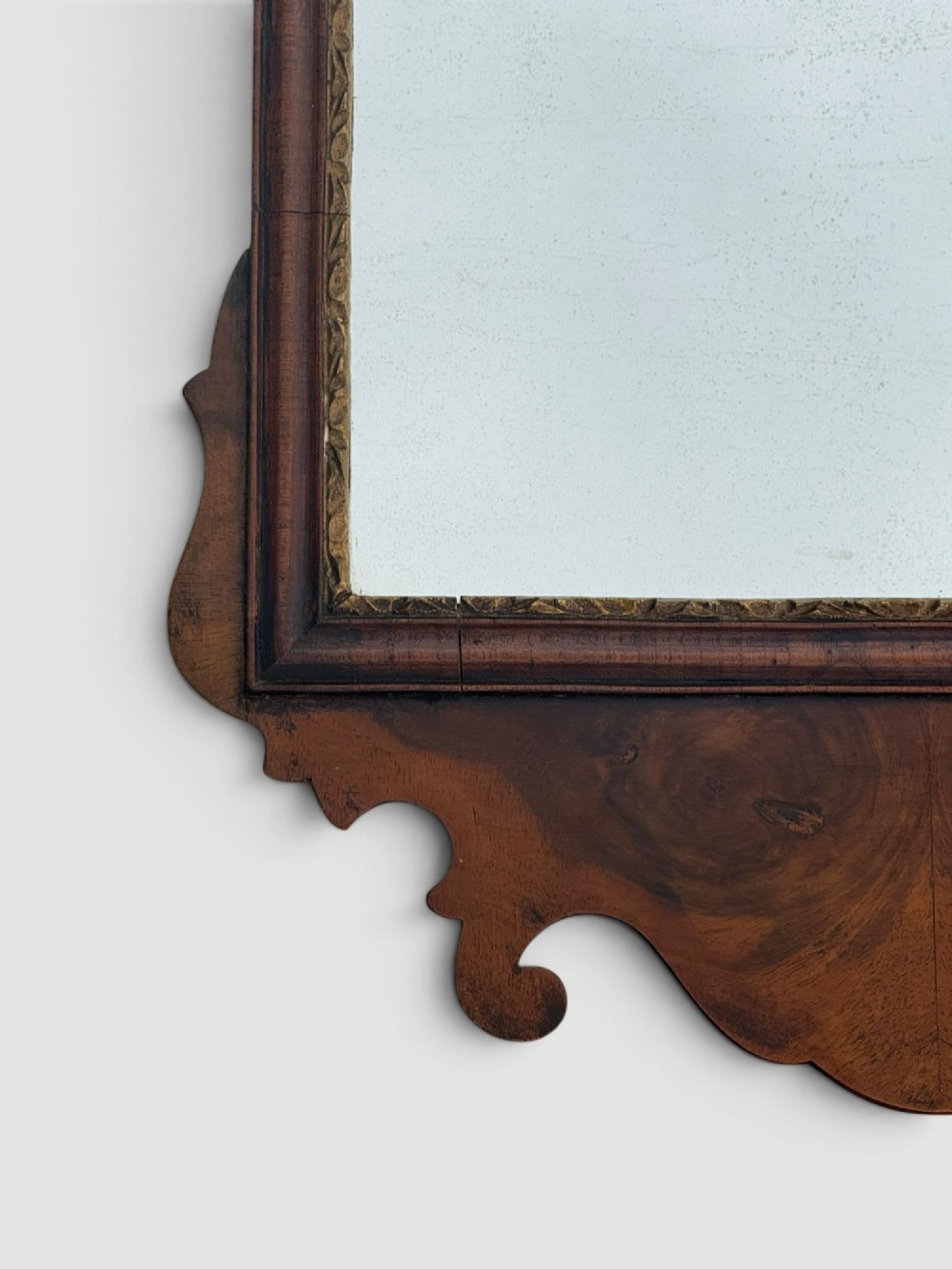 An 18th-century Georgian wall mirror featuring a carved walnut fretwork frame with a central gilded plume motif at the top. View IV