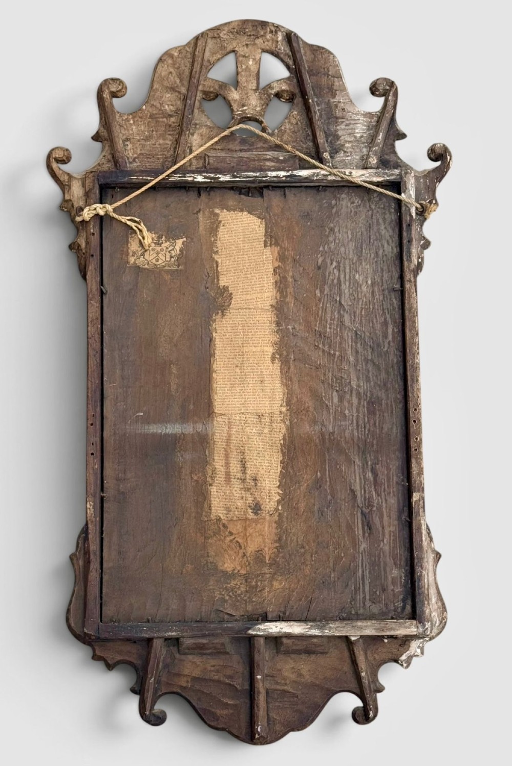 An 18th-century Georgian wall mirror featuring a carved walnut fretwork frame with a central gilded plume motif at the top. View VII