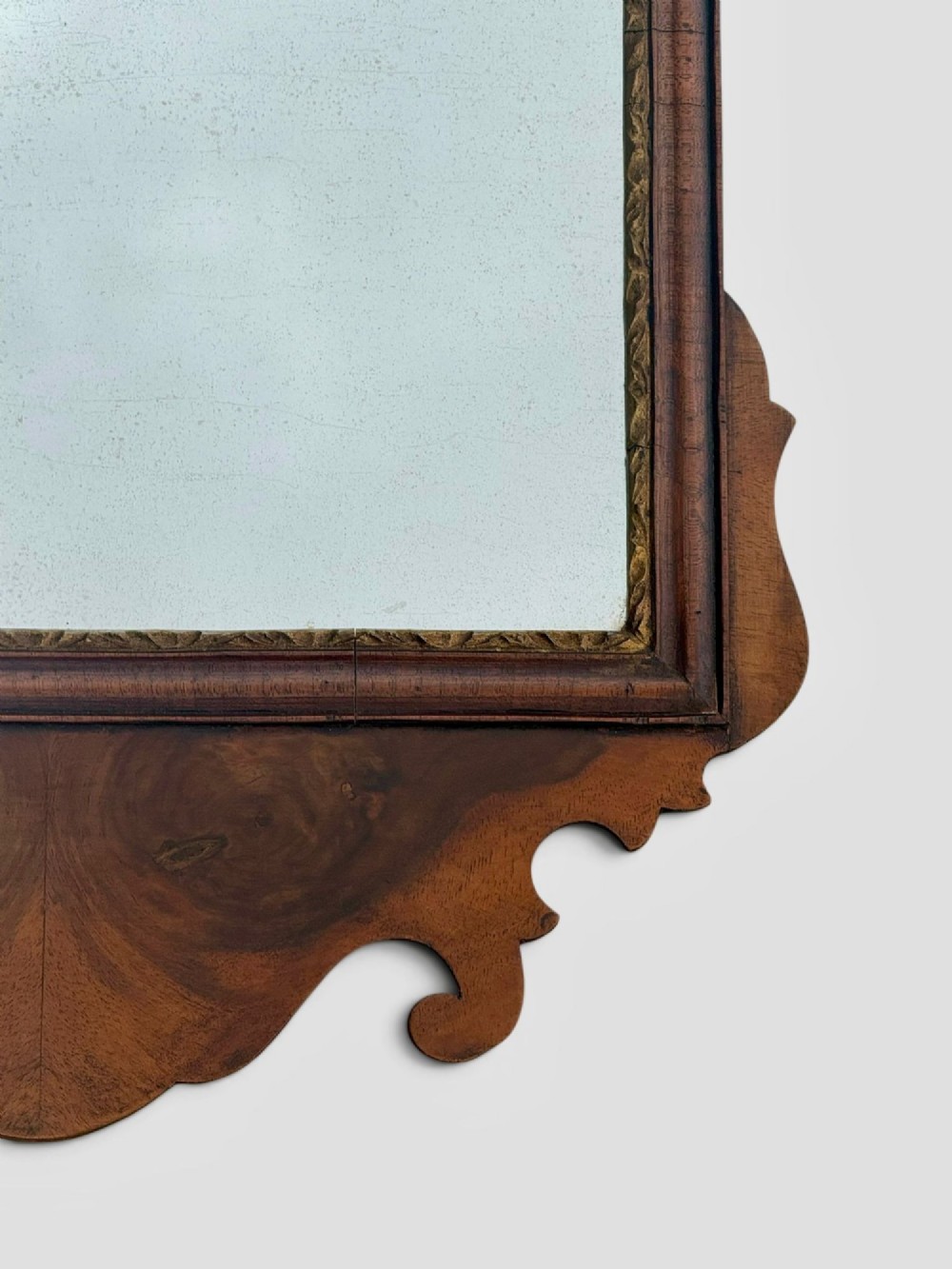 An 18th-century Georgian wall mirror featuring a carved walnut fretwork frame with a central gilded plume motif at the top. View VIII