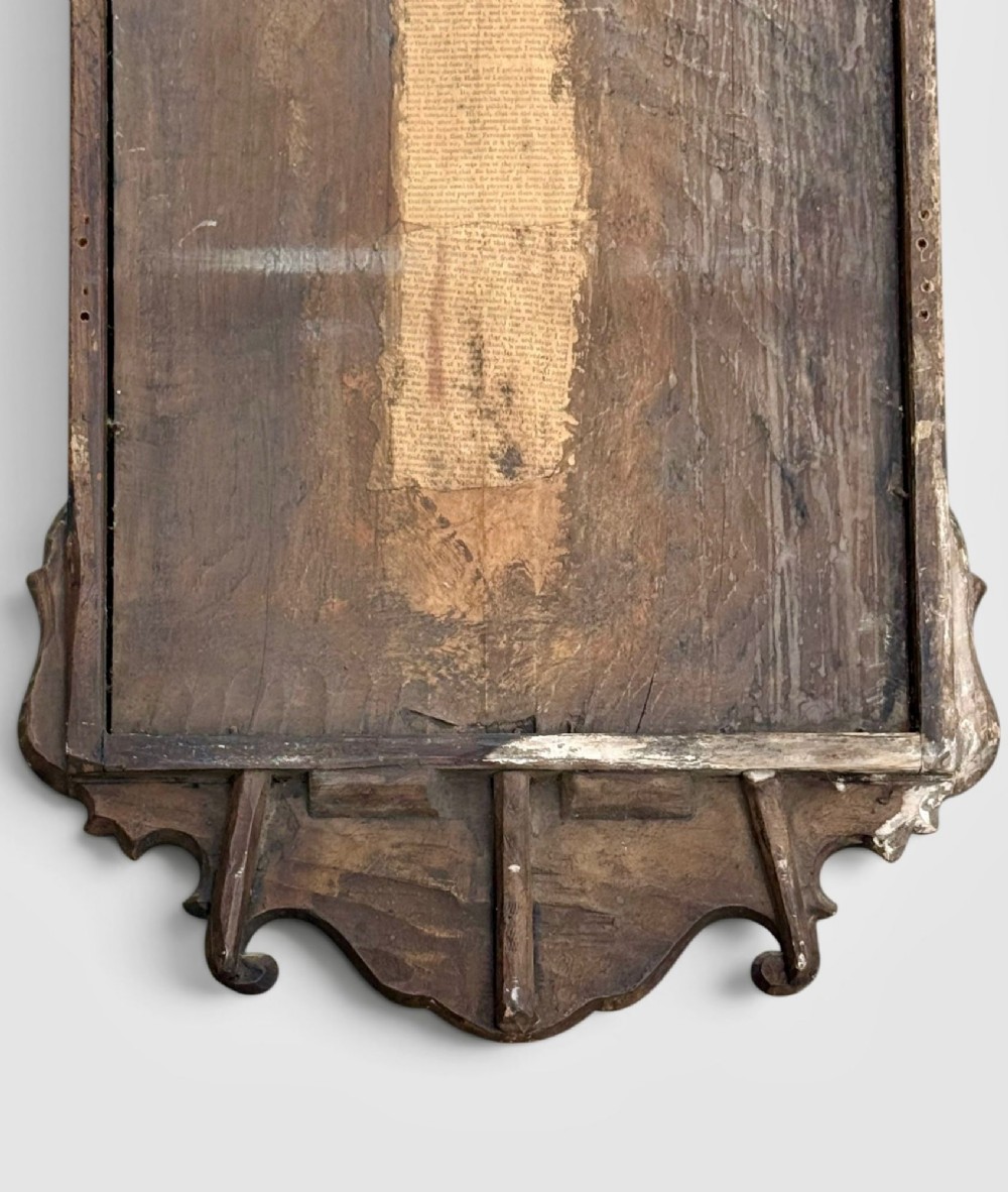An 18th-century Georgian wall mirror featuring a carved walnut fretwork frame with a central gilded plume motif at the top. View XI