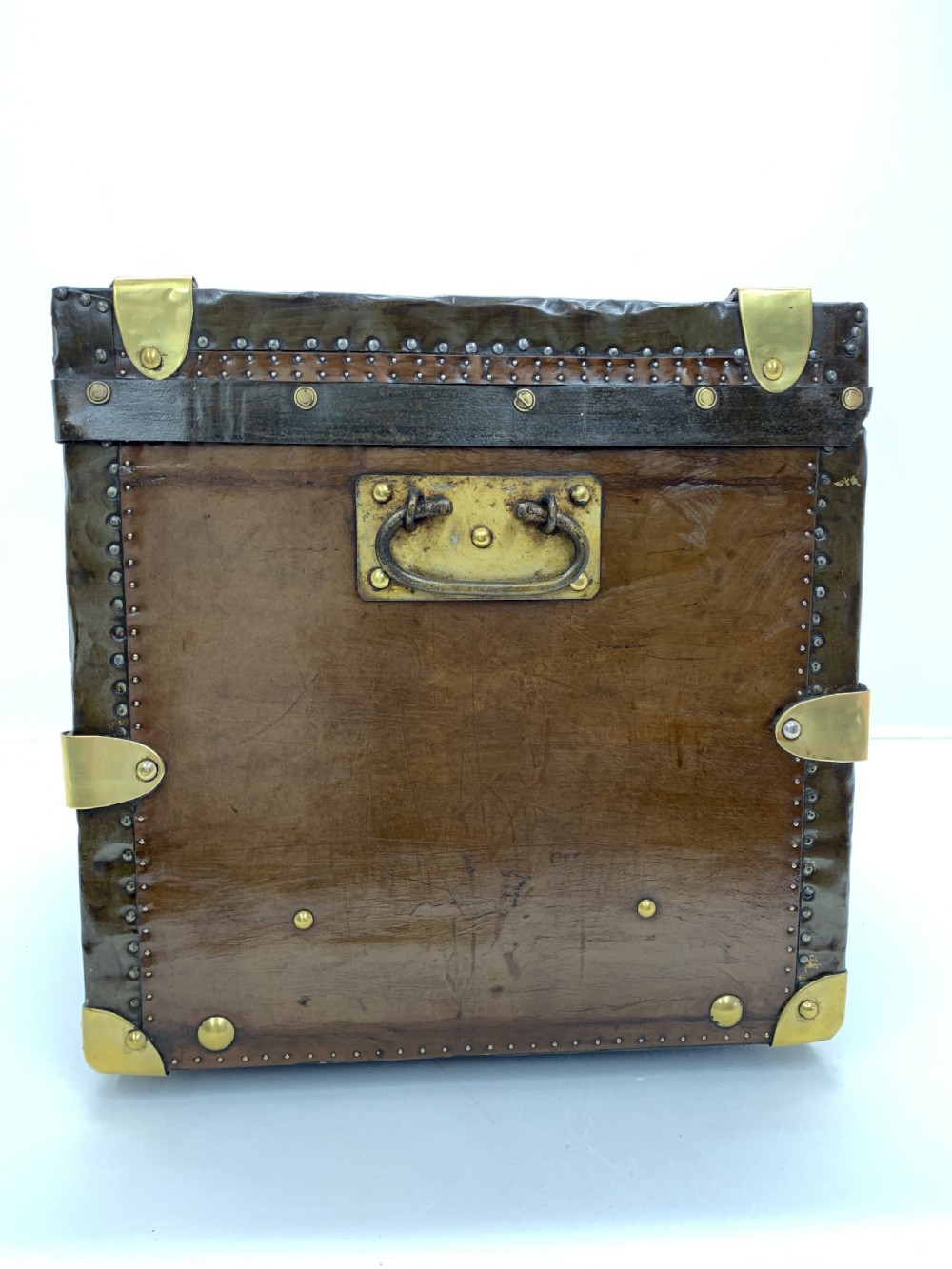 A dark brown antique leather steamer trunk featuring brass hardware, riveted metal stud trim, and wooden reinforcement bands. View II