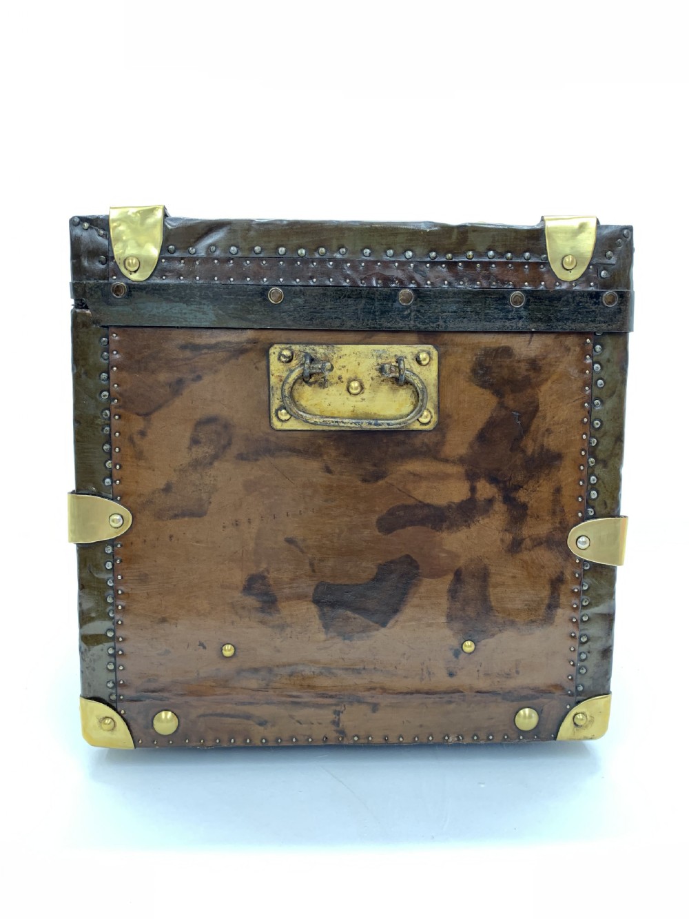 A dark brown antique leather steamer trunk featuring brass hardware, riveted metal stud trim, and wooden reinforcement bands. View V