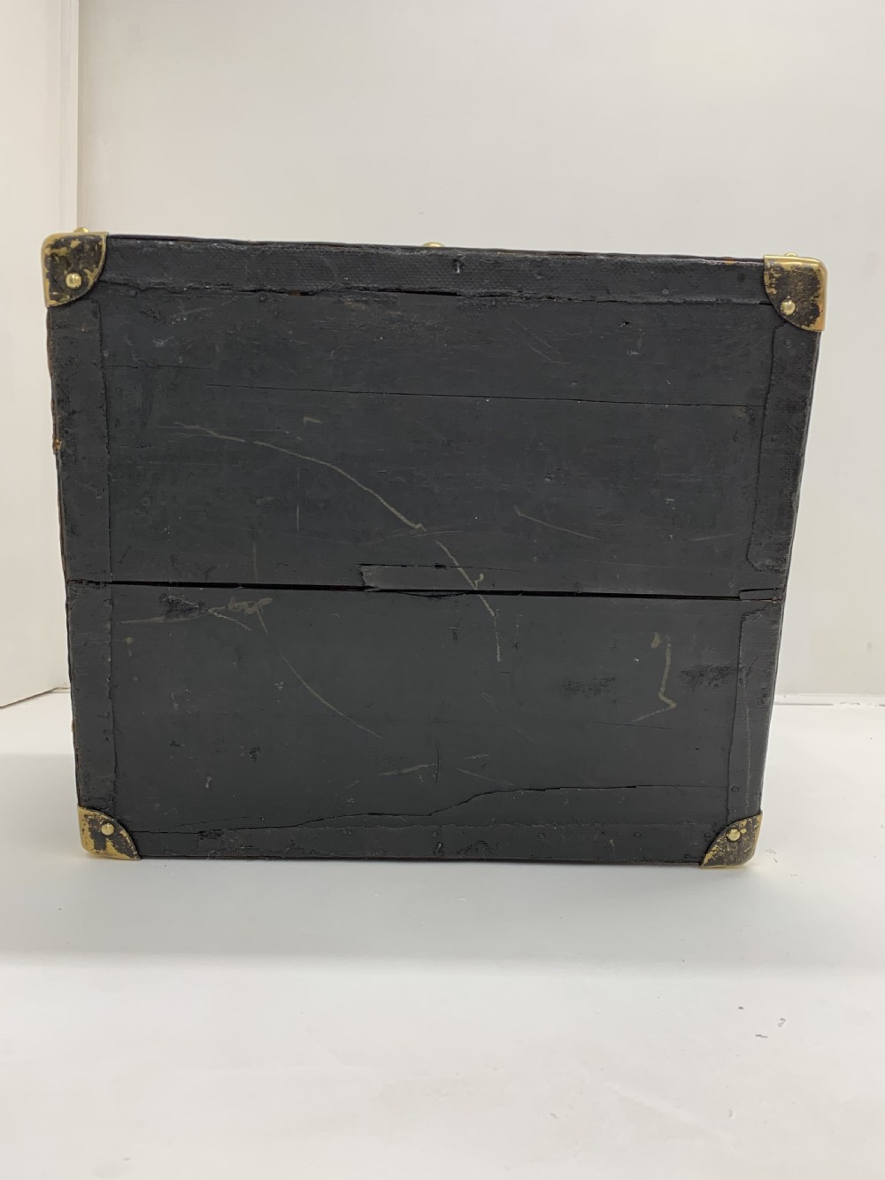 A dark brown antique leather steamer trunk featuring brass hardware, riveted metal stud trim, and wooden reinforcement bands. View VII