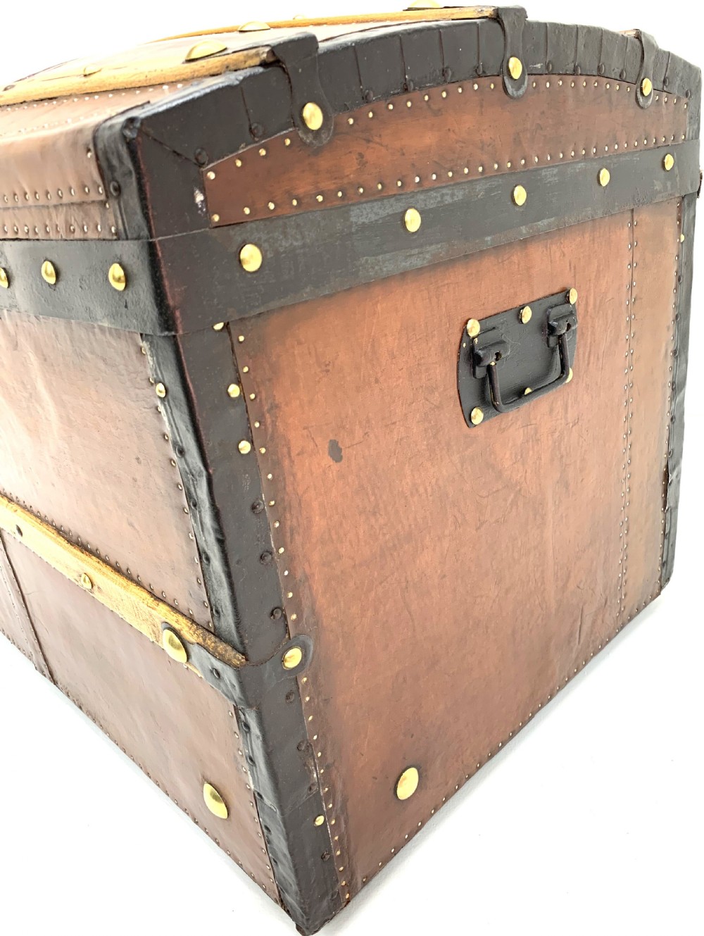 An antique leather-bound dome top steamer trunk with brass studs, wooden slats, and a central brass lock mechanism. View XIII