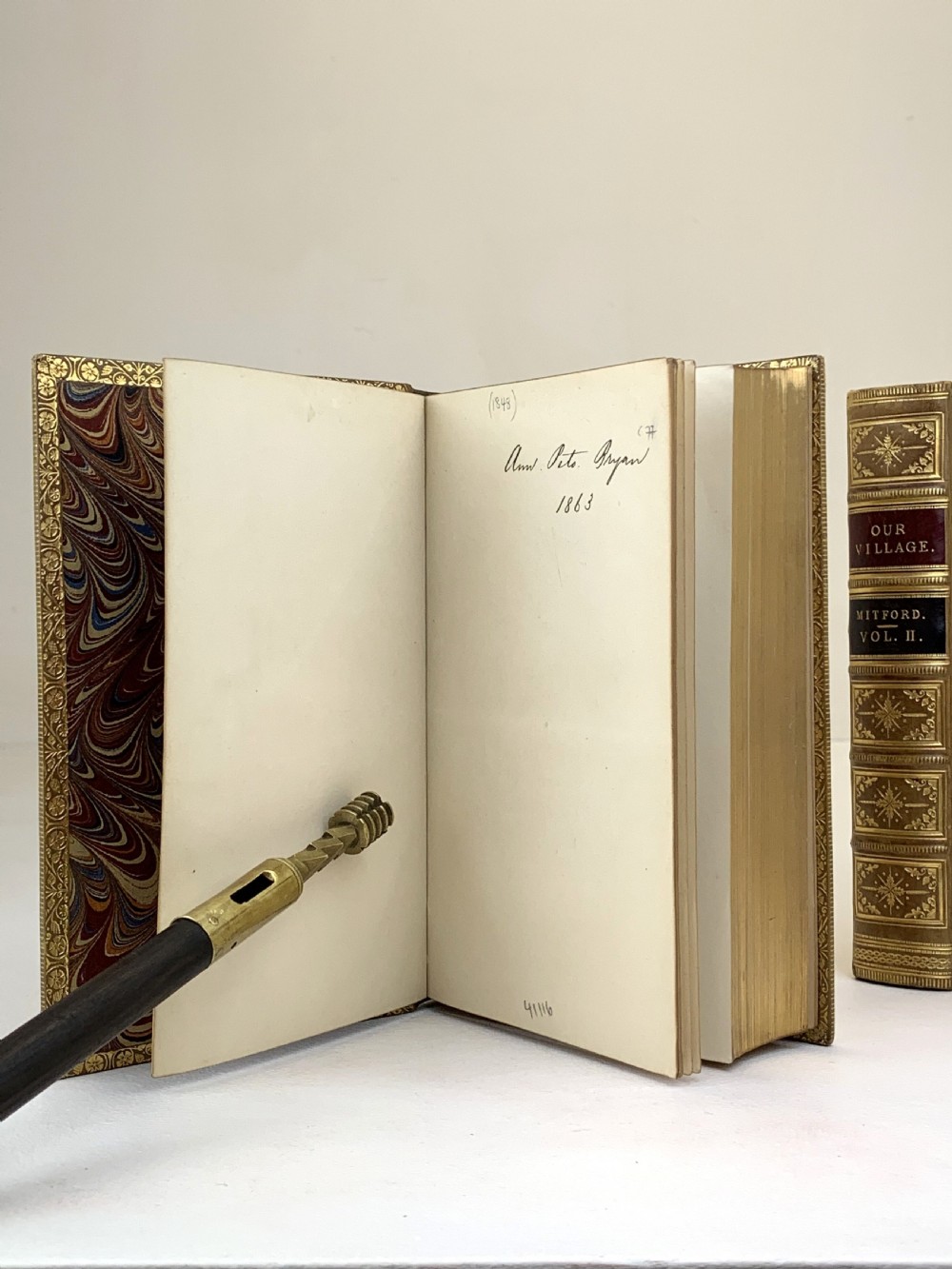 A two-volume set of 1848 leather-bound books titled Our Village, featuring elaborate gold tooling and raised spine bands. View XV
