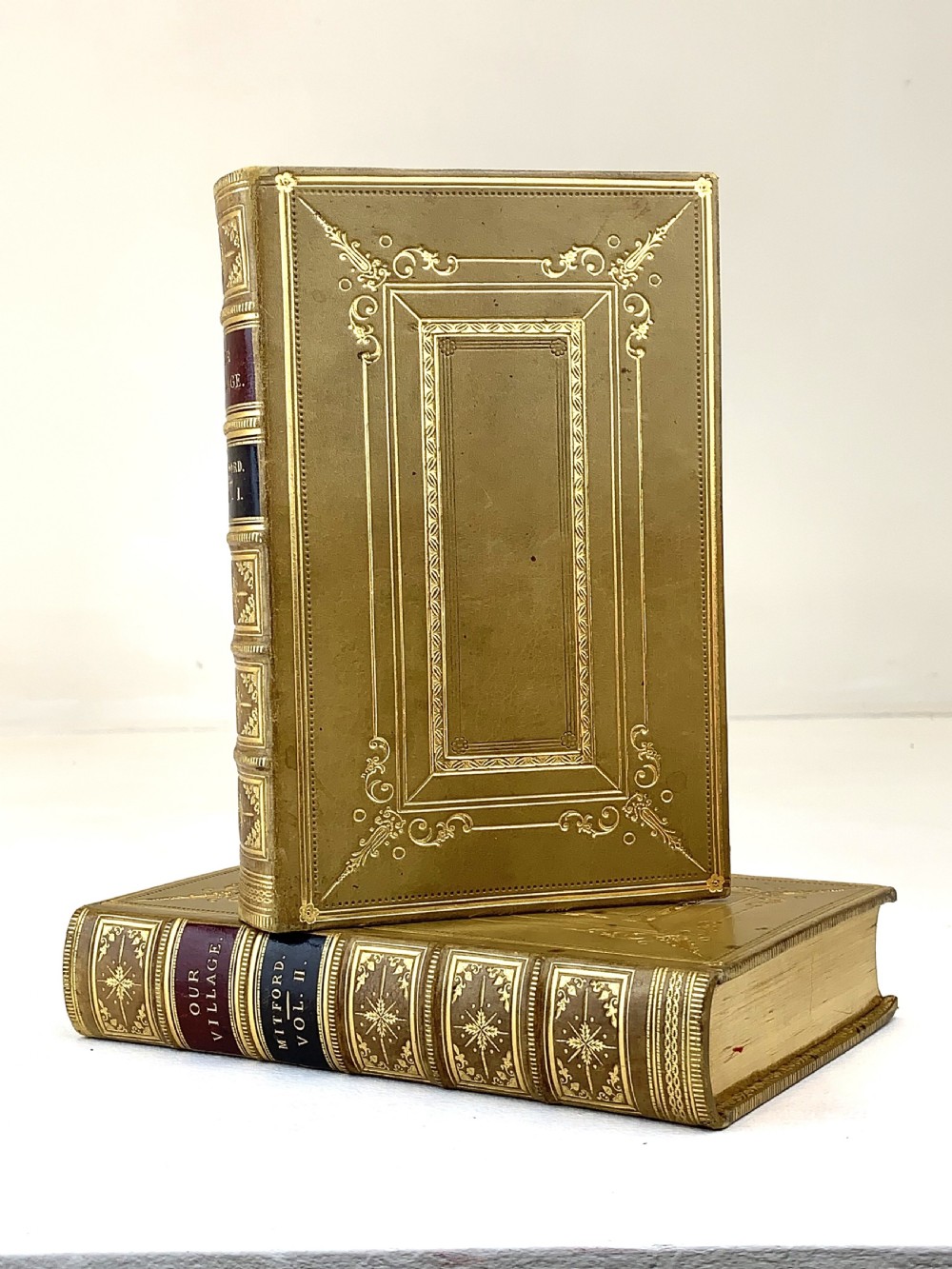 A two-volume set of 1848 leather-bound books titled Our Village, featuring elaborate gold tooling and raised spine bands. View XX