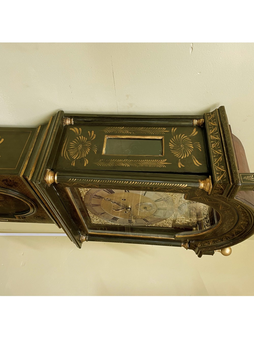 An antique dark green japanned longcase clock featuring gilded chinoiserie landscape details, an arched hood with gold finials, and a brass dial with a Tempus Fugit boss. View III