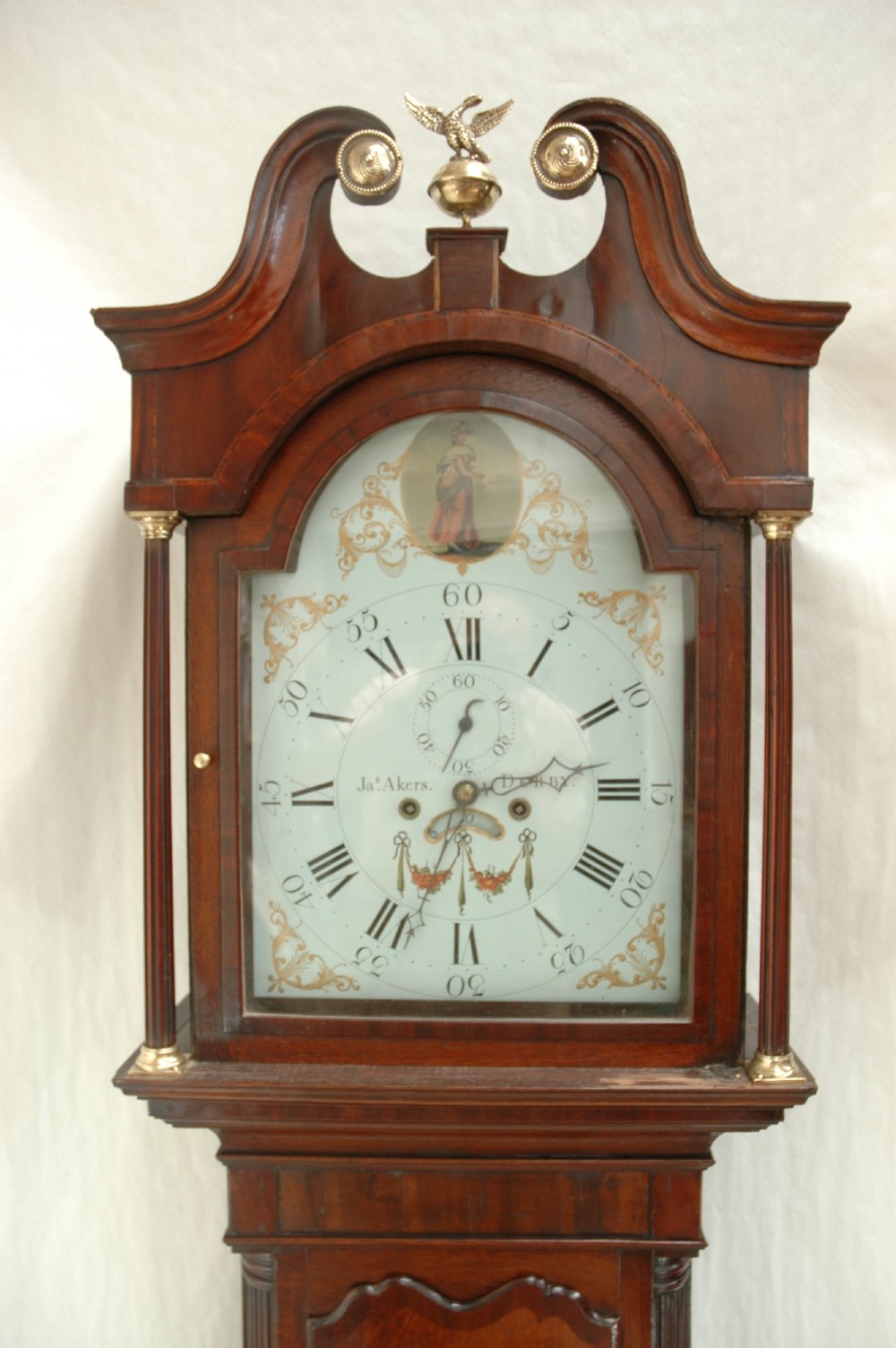 An antique Georgian mahogany longcase clock featuring a swan-neck pediment with brass finials and a painted arch dial. View II