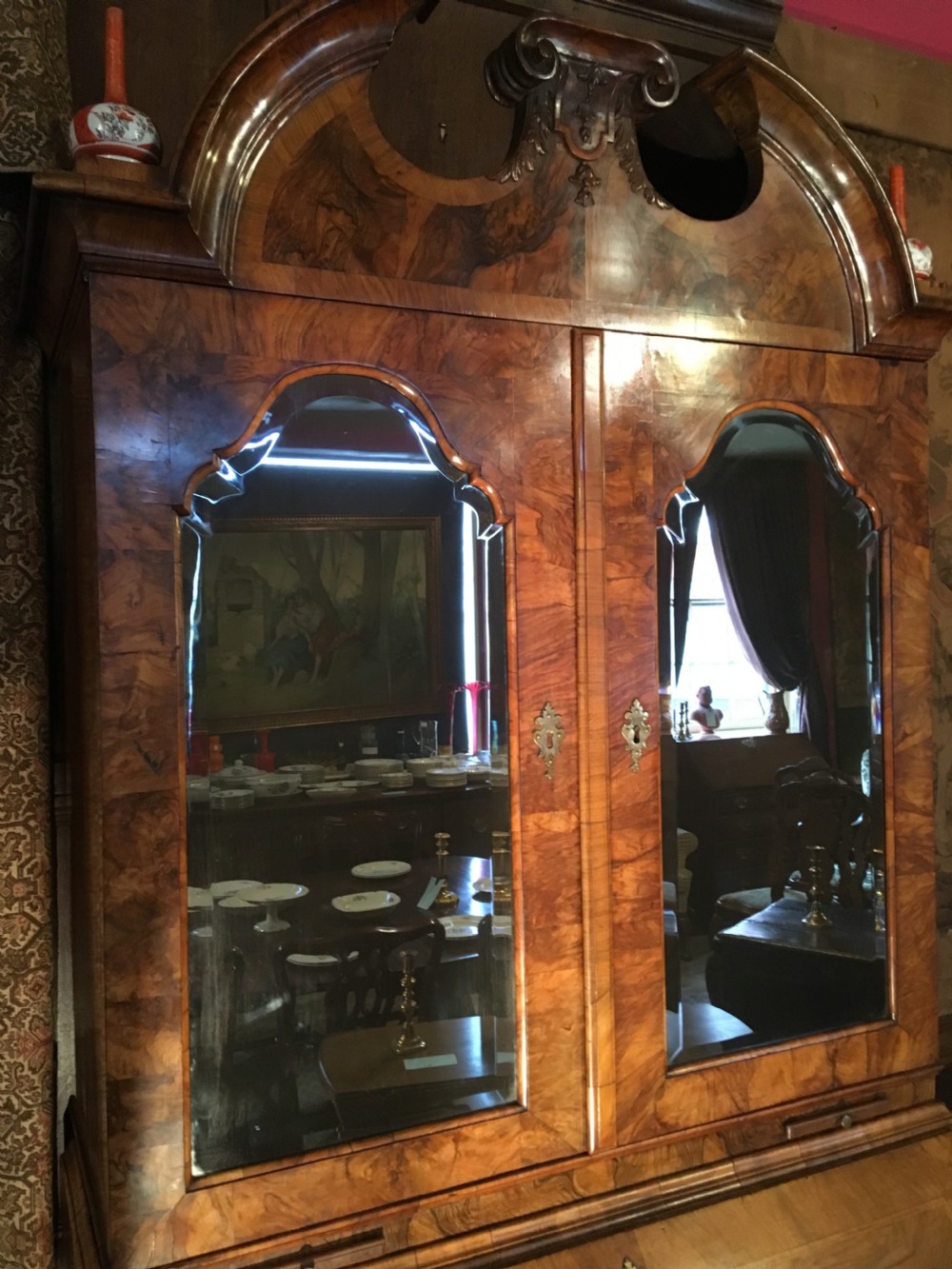 A George I walnut bureau bookcase featuring an arched pediment, two mirrored doors on the upper cabinet, and a sloping fall-front desk over three long drawers. View II