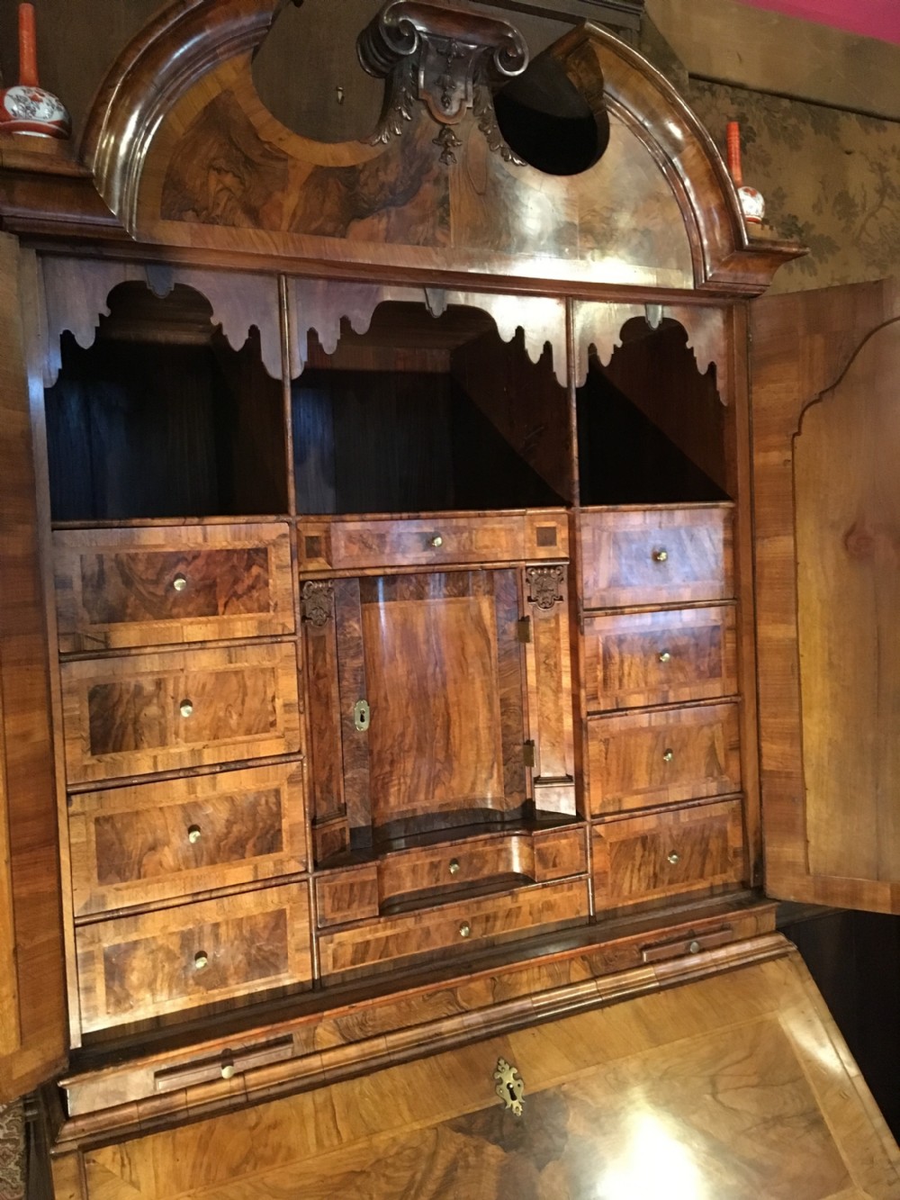 A George I walnut bureau bookcase featuring an arched pediment, two mirrored doors on the upper cabinet, and a sloping fall-front desk over three long drawers. View III