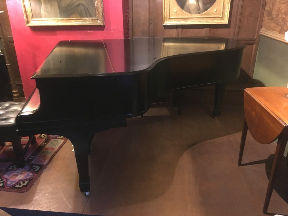An ebonised black Steinway Model B grand piano with an open lid, full keyboard, and brass lyre pedal assembly. View III