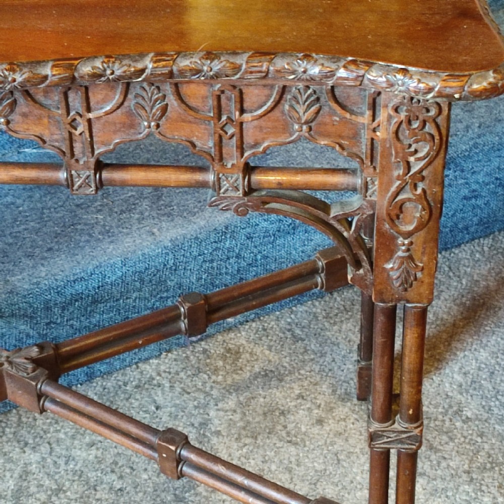 A nineteenth-century mahogany silver table crafted in the Chippendale style, featuring a shaped top, carved fretwork frieze, cluster-column legs, and an X-stretcher. View III