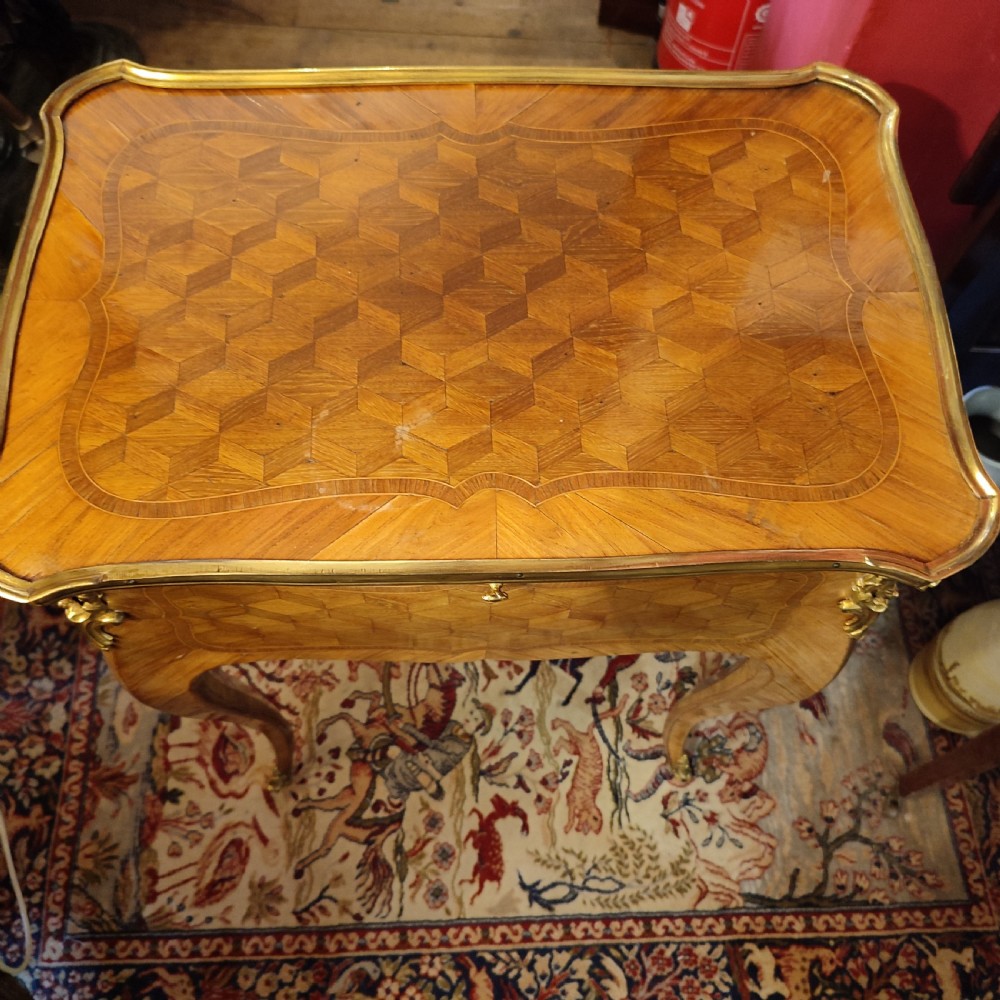 A French 19th-century kingwood writing table featuring geometric parquetry inlay, slender cabriole legs, and gilt bronze mounts. View V