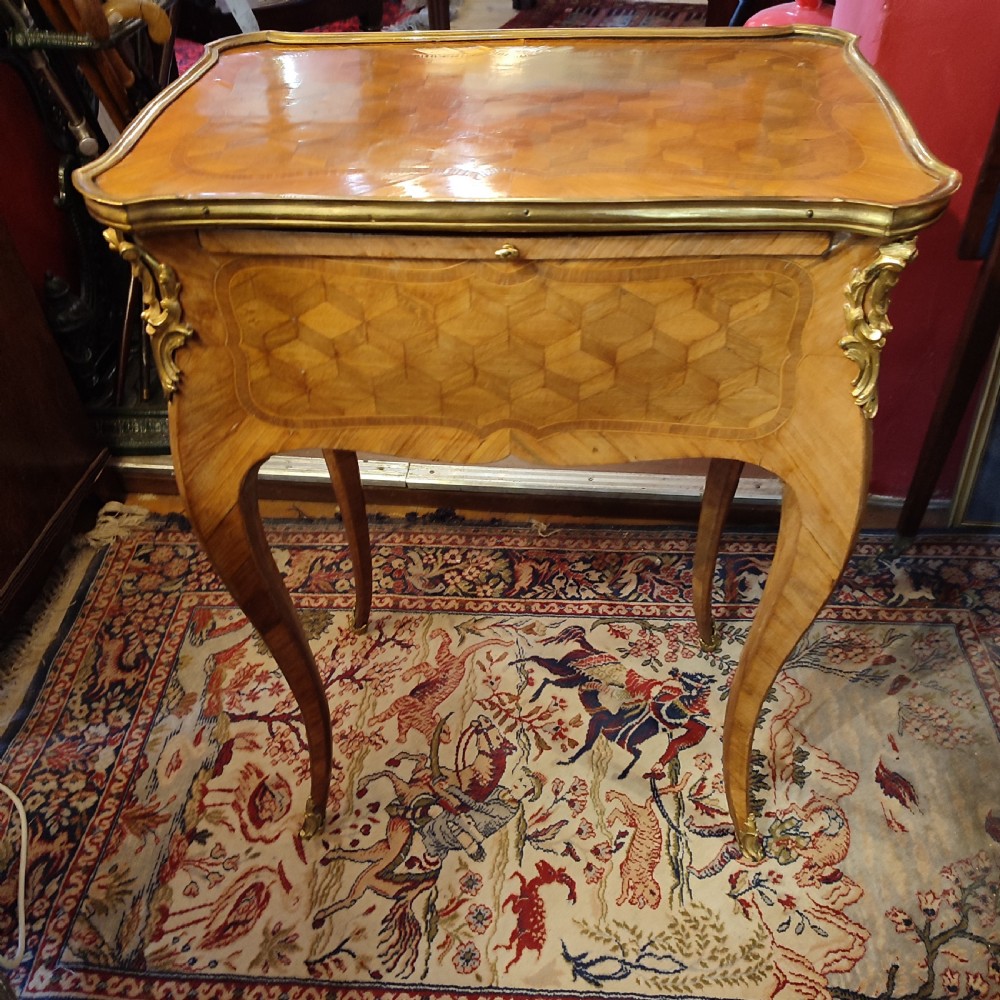 A French 19th-century kingwood writing table featuring geometric parquetry inlay, slender cabriole legs, and gilt bronze mounts. View VI