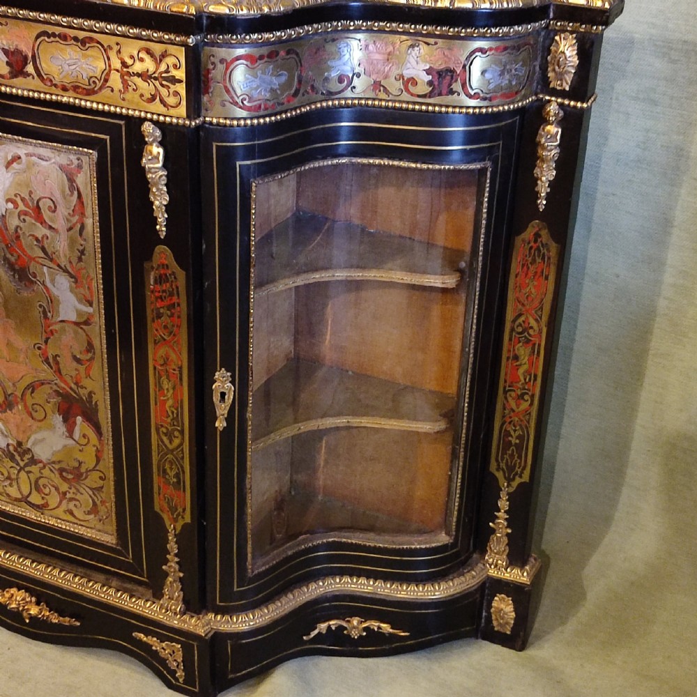 An ebonised 19th-century credenza featuring intricate brass and tortoiseshell Boulle marquetry, central panel with scrollwork, curved glazed side doors, and gilt bronze mounts. View V