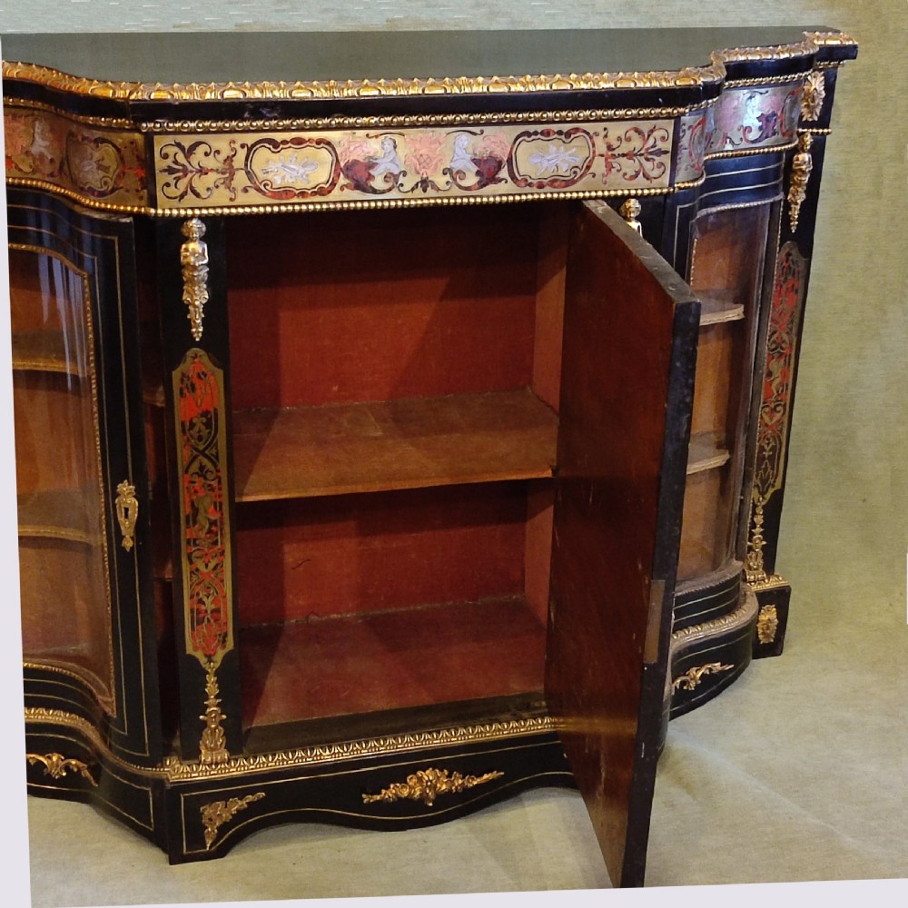 An ebonised 19th-century credenza featuring intricate brass and tortoiseshell Boulle marquetry, central panel with scrollwork, curved glazed side doors, and gilt bronze mounts. View VI