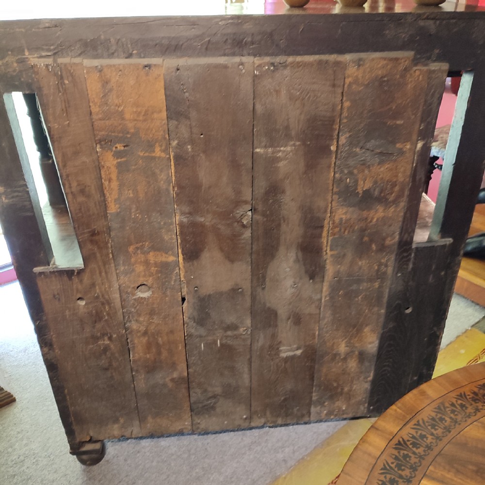 A late 17th-century dark oak court cupboard featuring geometric panel doors and turned baluster supports. View VII
