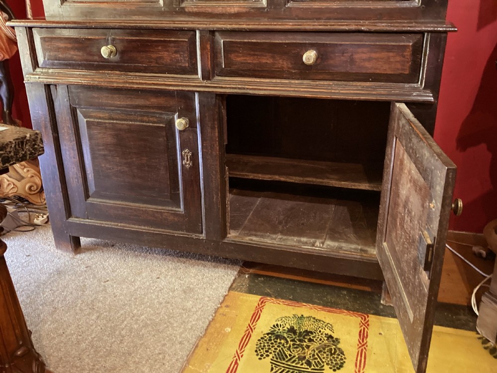 An early eighteenth-century dark oak three-tier Welsh tridarn featuring an open upper canopy, panelled cupboard doors, drawers, and turned balusters. View III