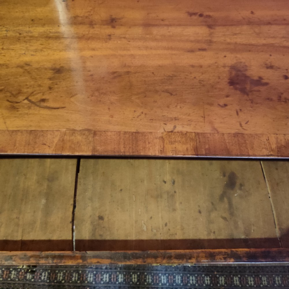 A George I period warm brown walnut chest of drawers featuring figured grain, crossbanded drawer fronts, brass drop handles, and bracket feet. View III