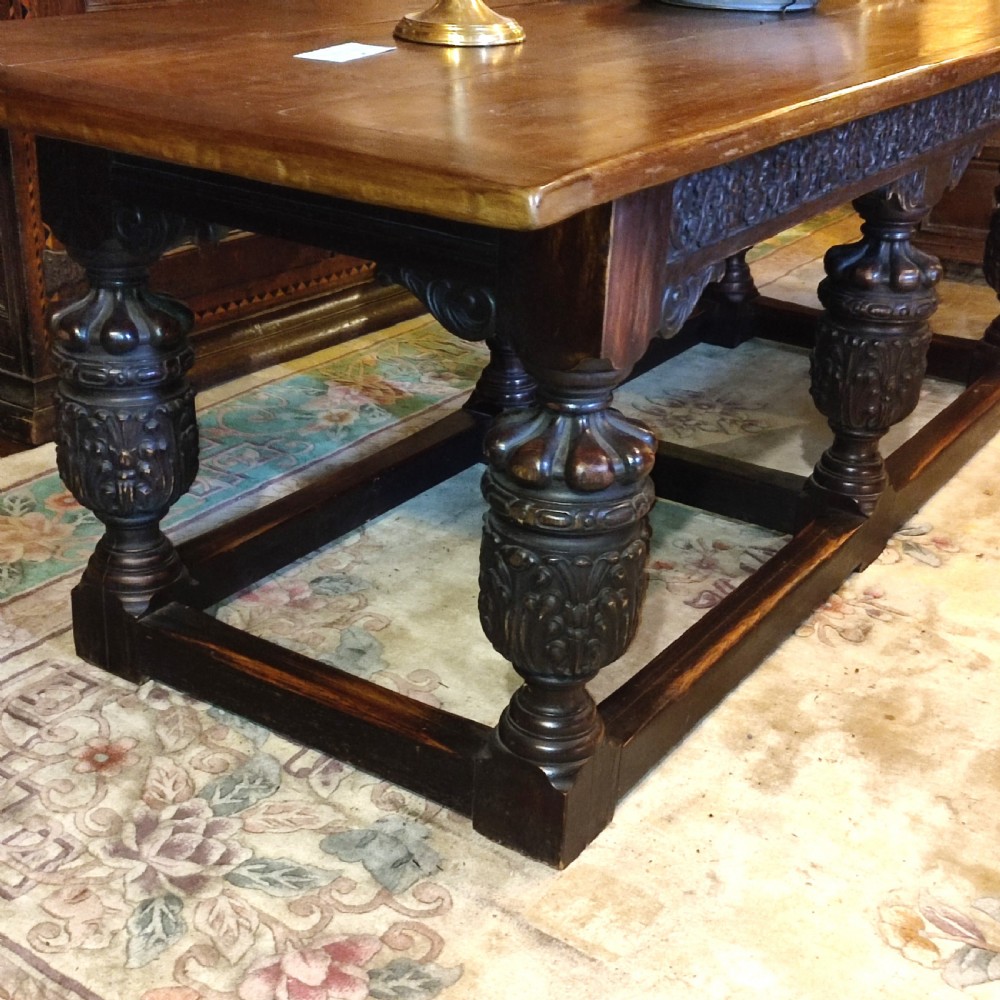 A long 19th-century oak and red walnut refectory table featuring heavily carved bulbous legs joined by a low perimeter box stretcher. View II