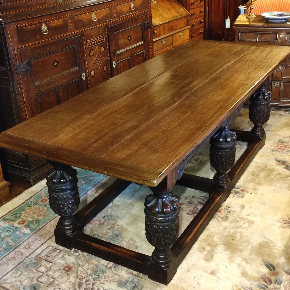 A long 19th-century oak and red walnut refectory table featuring heavily carved bulbous legs joined by a low perimeter box stretcher. View III