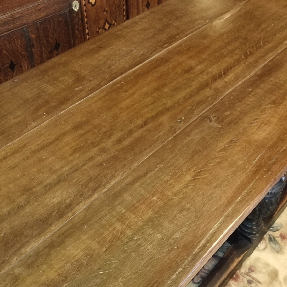 A long 19th-century oak and red walnut refectory table featuring heavily carved bulbous legs joined by a low perimeter box stretcher. View IV