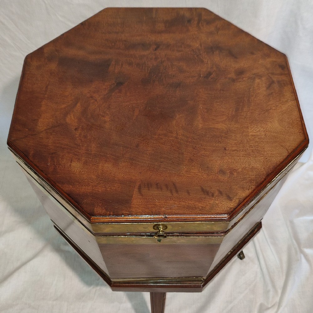 An octagonal Regency mahogany cellarette with brass banding, raised on fluted tapered legs with brass castors. View III