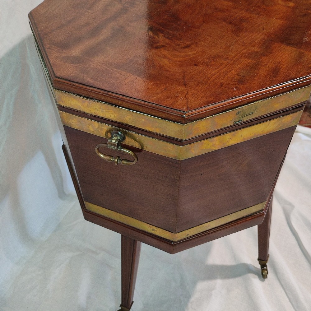 An octagonal Regency mahogany cellarette with brass banding, raised on fluted tapered legs with brass castors. View IV
