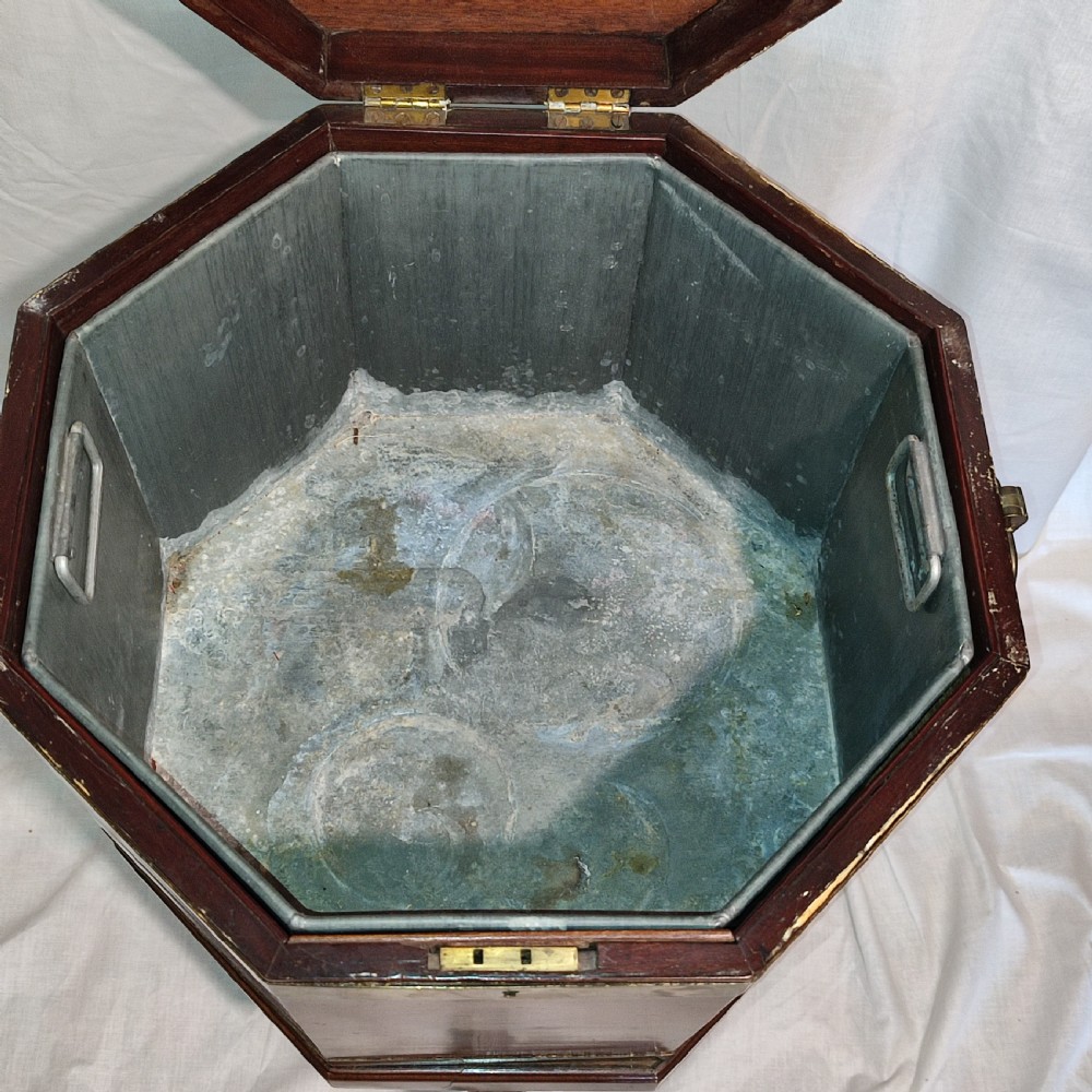 An octagonal Regency mahogany cellarette with brass banding, raised on fluted tapered legs with brass castors. View V