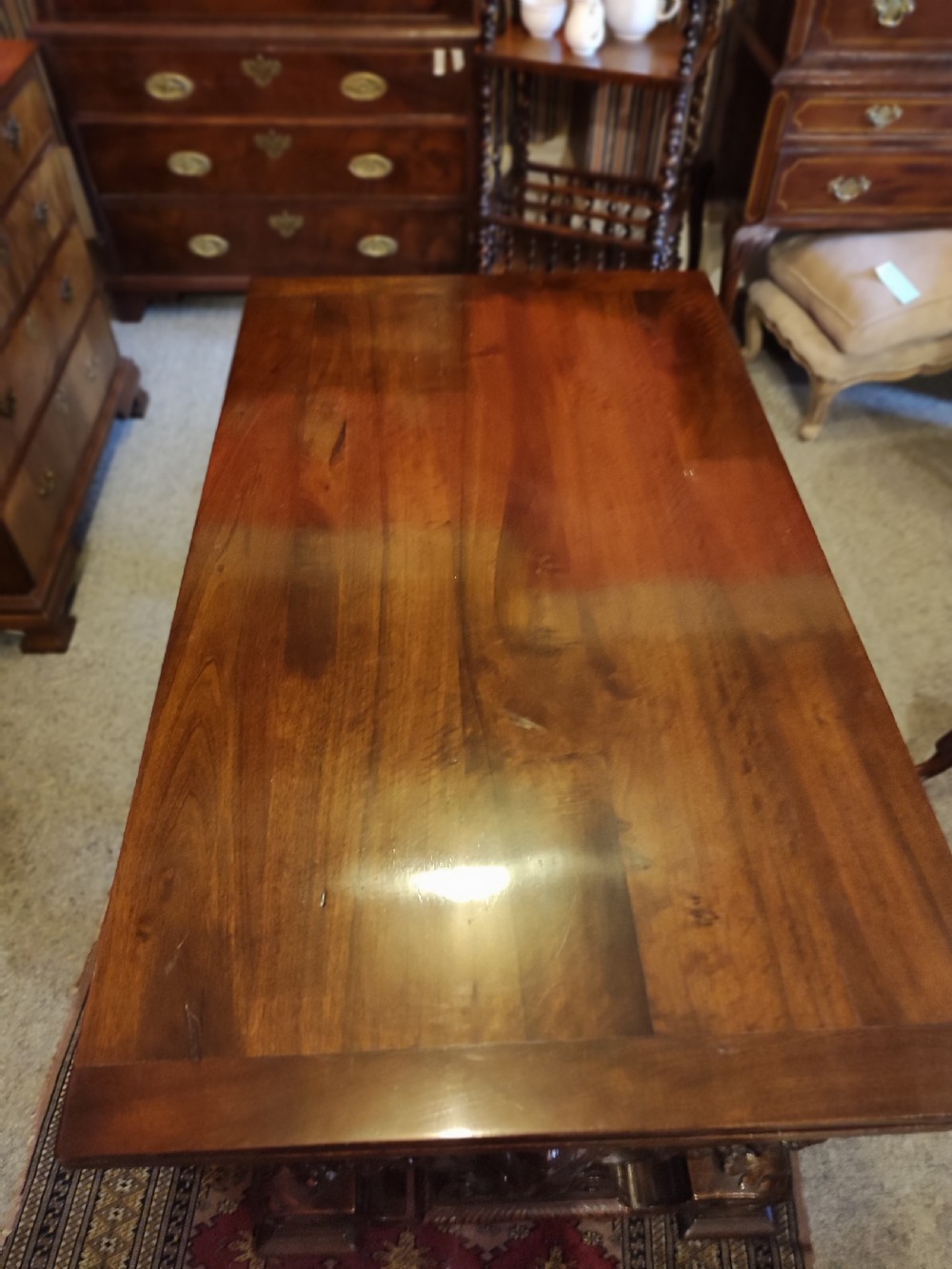 A 19th-century dark walnut extending dining table featuring a polished rectangular top with fully extended side leaves, supported on a heavily carved stretcher base. View IV