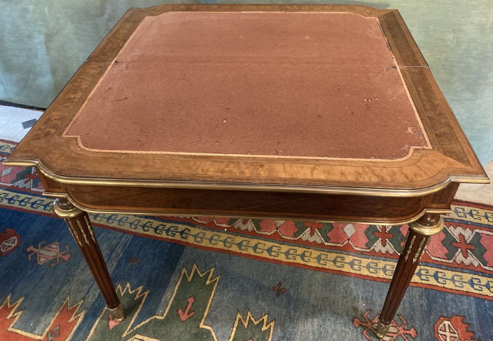 A 19th-century walnut card table featuring a floral marquetry top, brass ormolu trim, fluted tapering legs, and a hinged flip-top. View IV