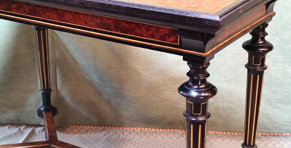 An antique amboyna and ebony card table featuring intricate wood grain and turned legs. View IV