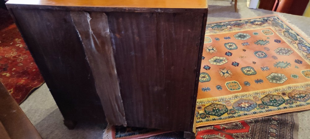 A rectangular yew wood kneehole desk featuring multiple drawers, a central recessed cupboard door, and brass drop handles. View VI