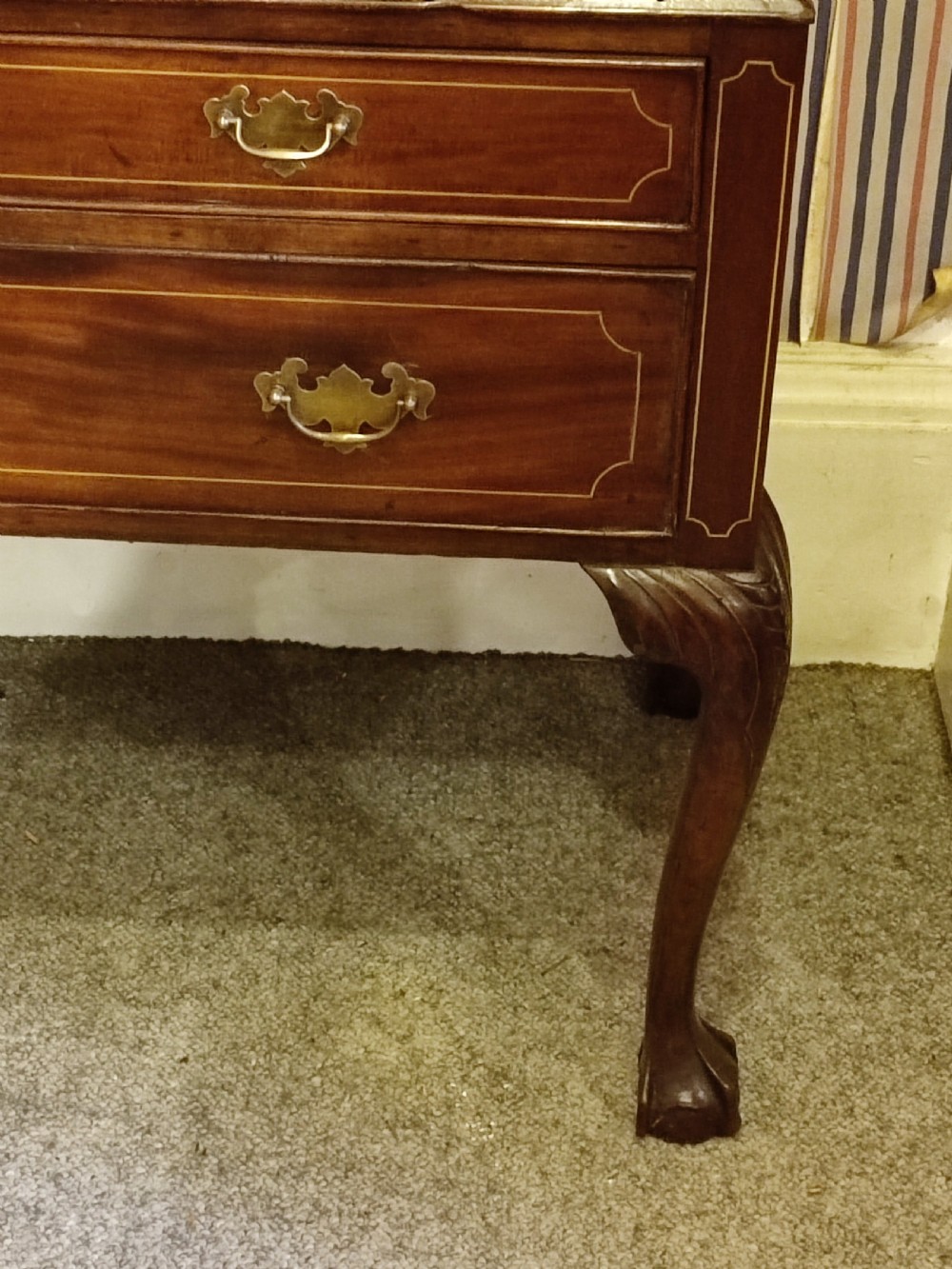 A tall 19th-century mahogany chest on stand featuring a swan-neck pediment with finial, line-inlaid drawer fronts, brass swan-neck handles, and cabriole legs. View IV