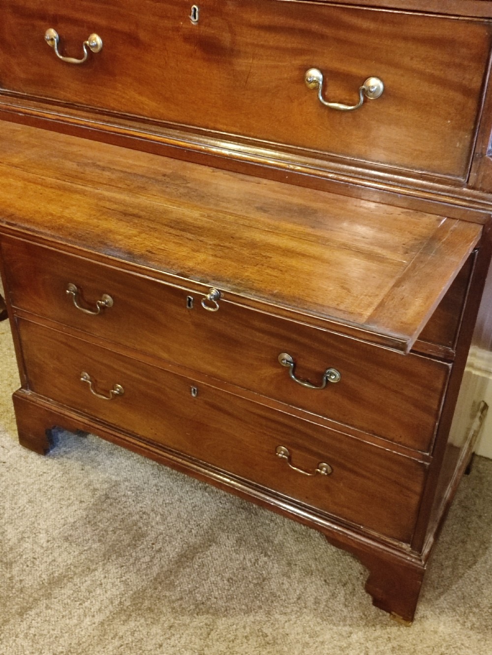 An 18th-century Georgian mahogany chest on chest featuring original brass swan-neck handles, dentil moulding along the cornice, and bracket feet. View II