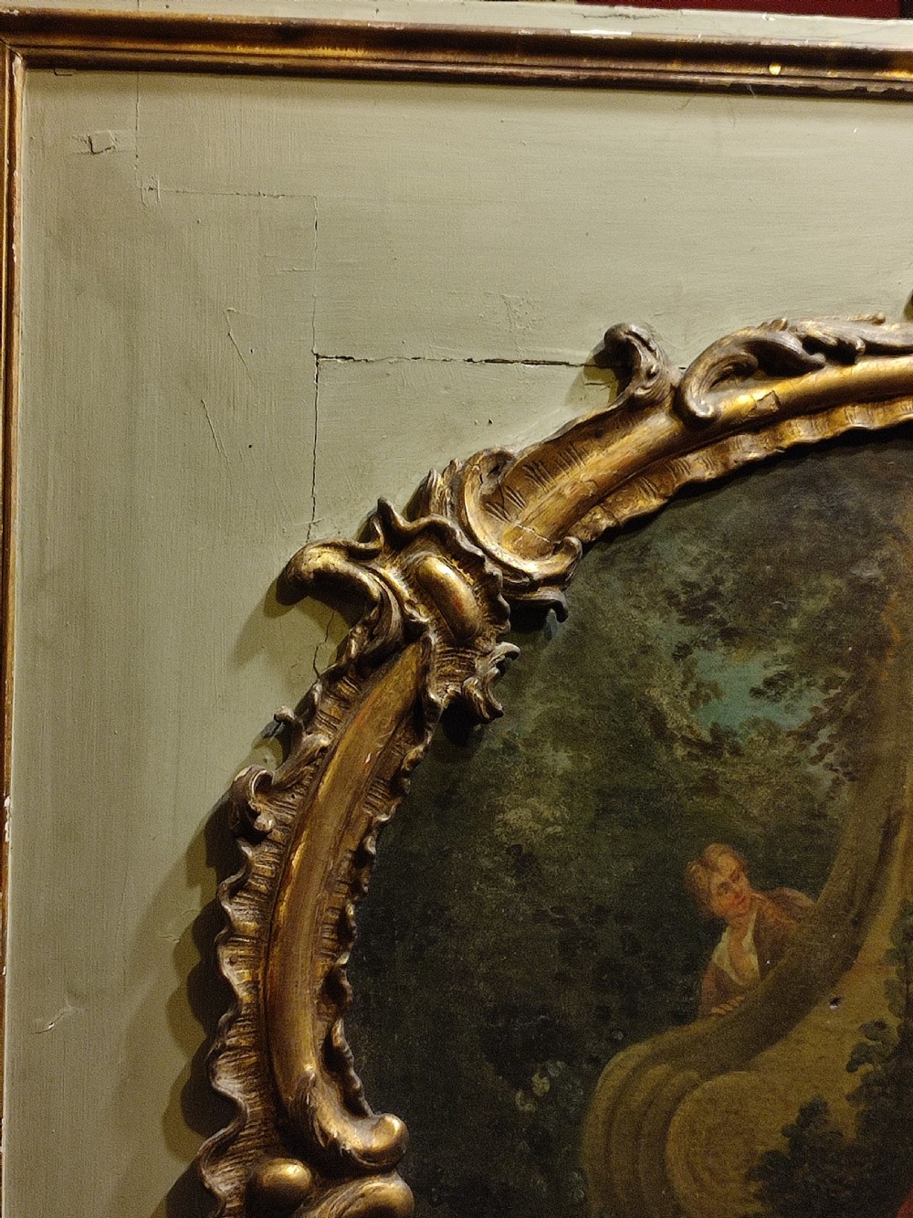 A large nineteenth-century French trumeau mirror featuring a painted canvas of a romantic pastoral scene above a mirror glass, set within carved giltwood frames on a grey painted panel. View IV