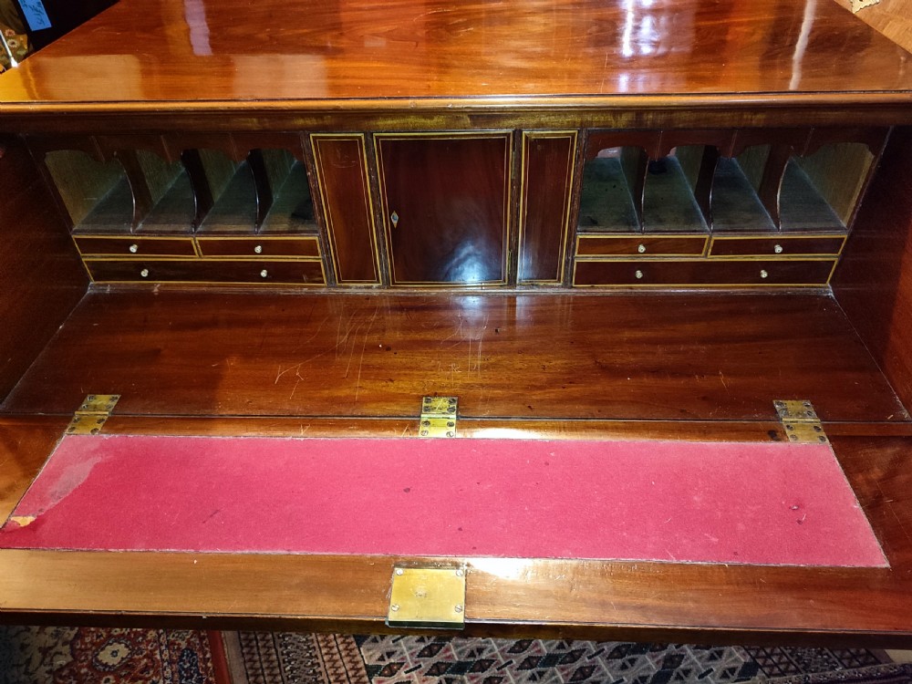 A Regency period mahogany secretaire chest with an open drop-front writing flap showing internal pigeonholes and miniature drawers. View II