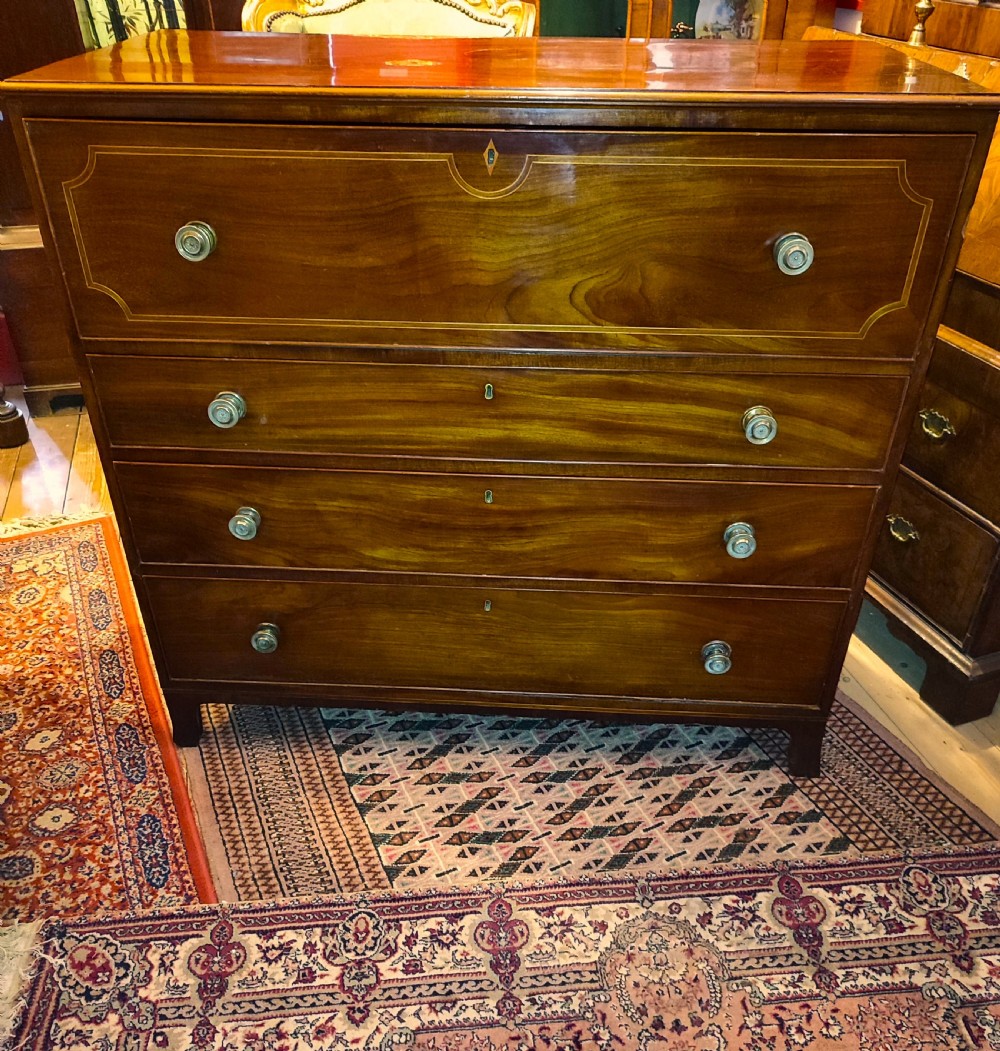 A Regency period mahogany secretaire chest with an open drop-front writing flap showing internal pigeonholes and miniature drawers. View III