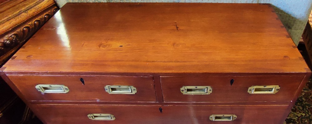A Regency period teak campaign chest of drawers featuring inset brass handles and side carrying hardware. View IV