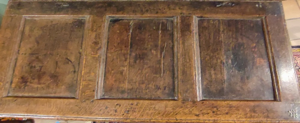 A 17th century dark oak coffer featuring carved lunette arches, inlaid geometric borders, three front panels, and a fitted iron lock escutcheon. View III
