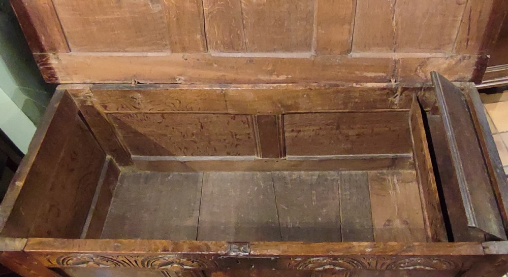 A 17th century dark oak coffer featuring carved lunette arches, inlaid geometric borders, three front panels, and a fitted iron lock escutcheon. View IV